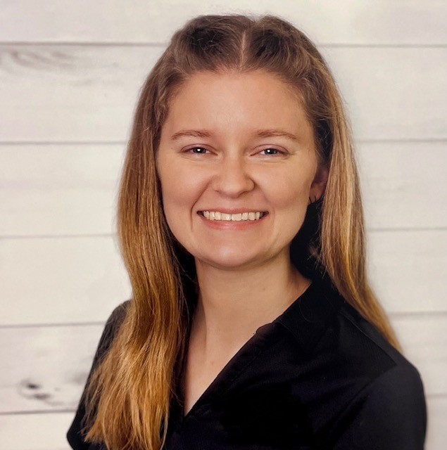 Shayla Alexander, white young female with shoulder length brown hair and blue eyes wearing a black polo shirt
